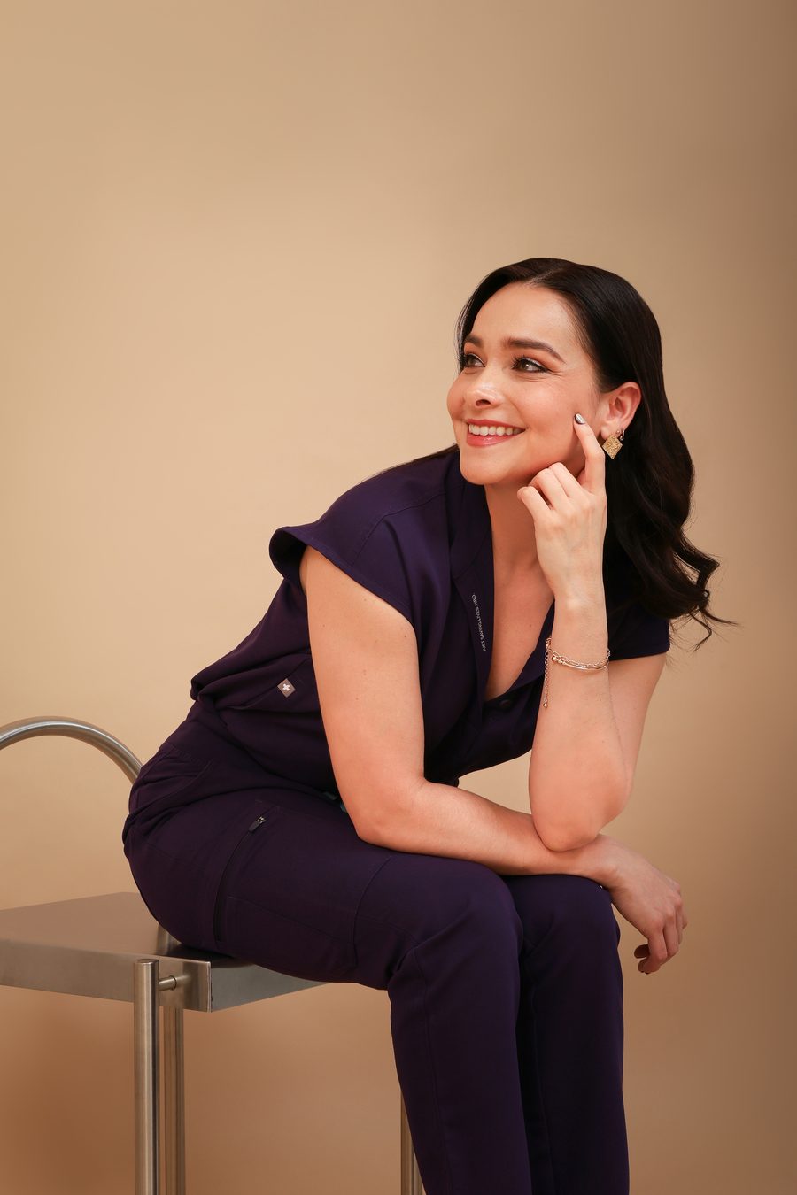 Dra. Lizbeth Ortega con uniforme médico morado, sonriendo