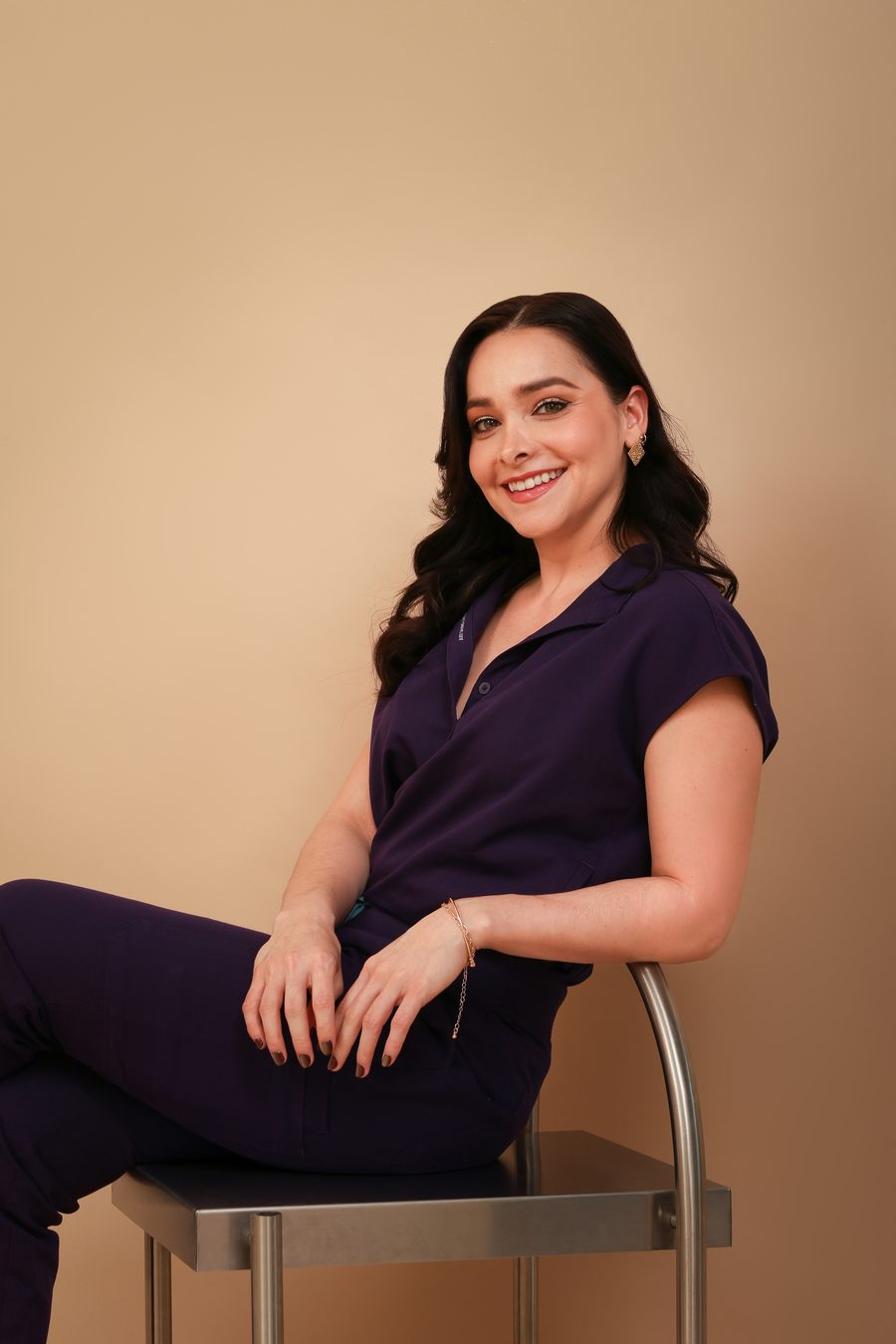 Dra. Lizbeth Ortega con uniforme médico morado, retrato lateral
